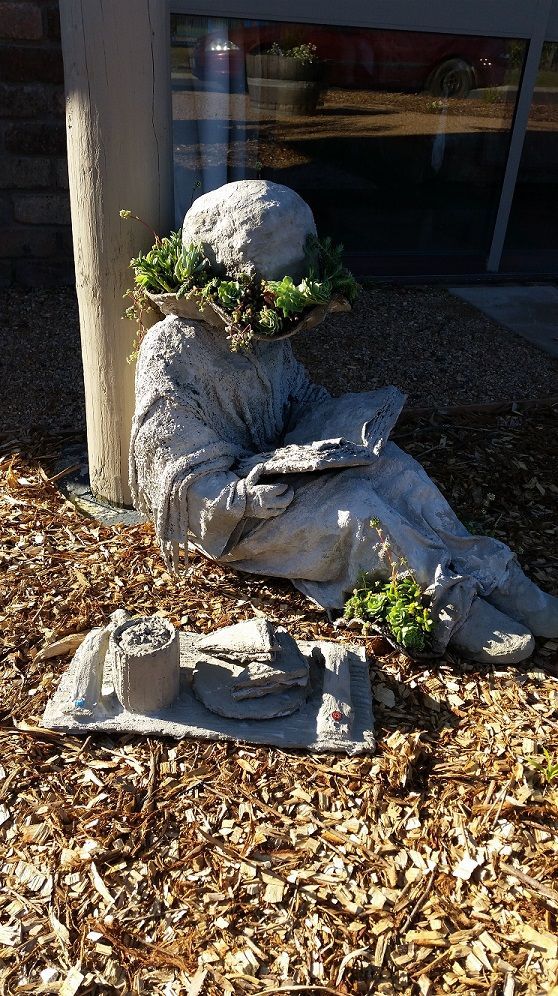 there is a statue that has been placed on the ground in front of a building