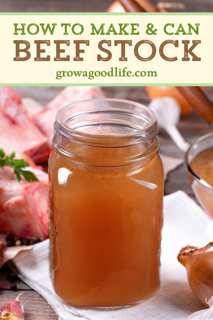 a mason jar filled with homemade beef stock next to garlic and meat cloves