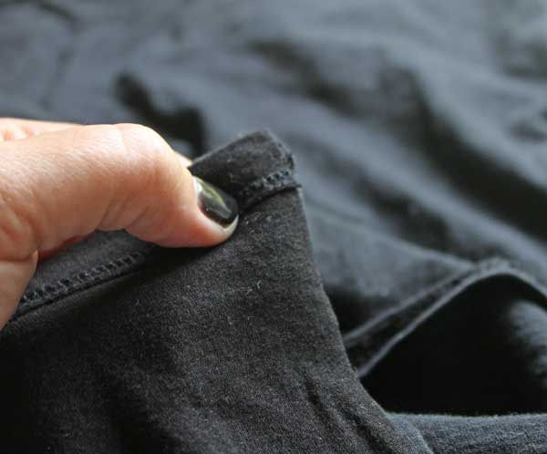 a person's hand on the pocket of a pair of black pants