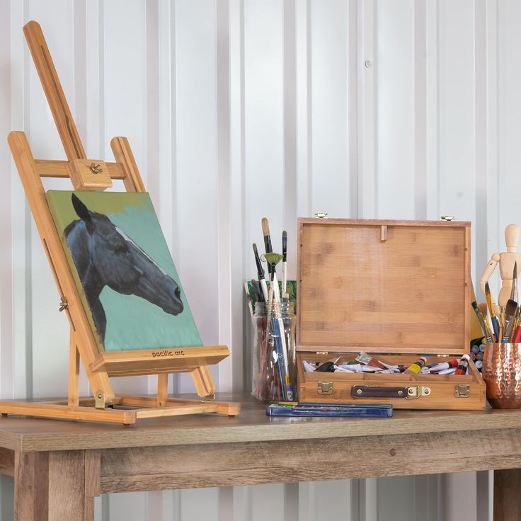 a wooden easel sitting on top of a table filled with art and craft supplies