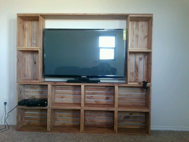 a flat screen tv sitting on top of a wooden entertainment center next to a wall