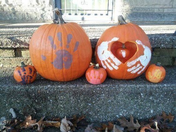 three pumpkins with handprints on them sitting on the steps