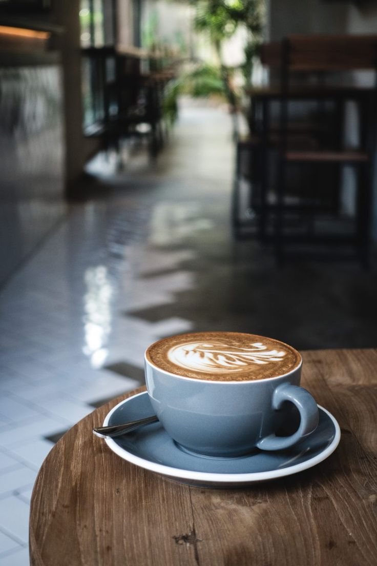 a cappuccino sitting on top of a wooden table