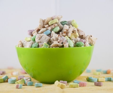 a green bowl filled with cereal and marshmallows on top of a table