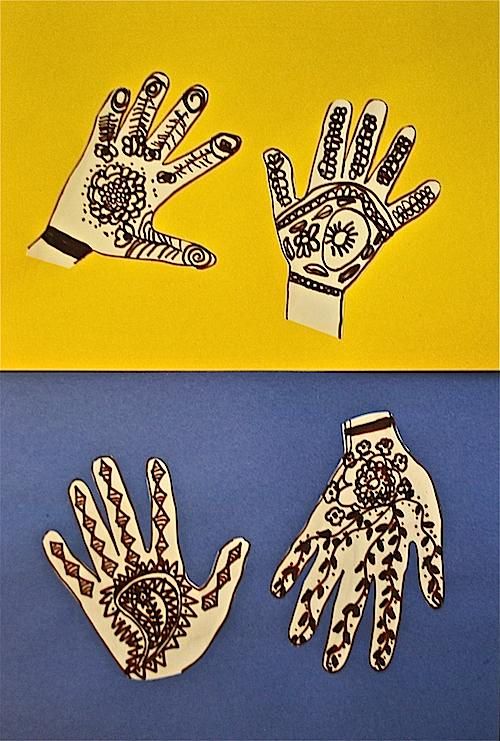 paper cutouts of two hands with designs on them