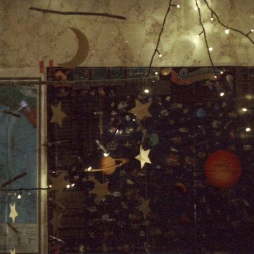 an image of a window with stars and planets in the glass, as well as lights on the wall