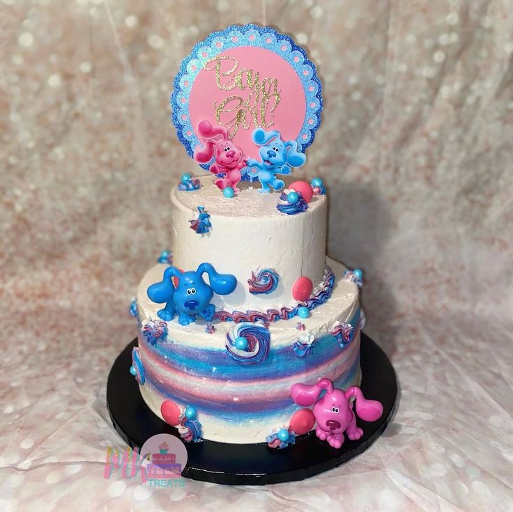 a three tiered cake with blue and pink frosting