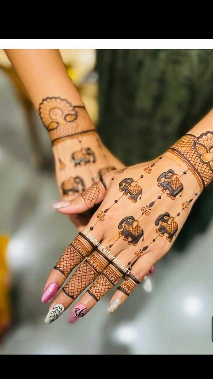 a woman's hands with hennap and tattoos on her hand, showing the design