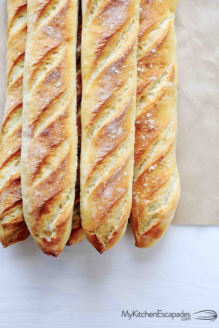 four loaves of bread sitting on top of a white countertop next to each other