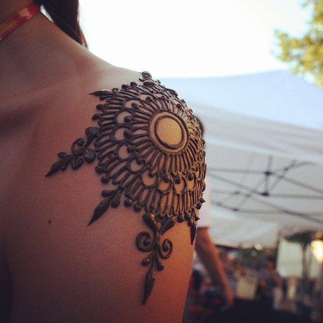 the back of a woman's shoulder with an intricate design on it