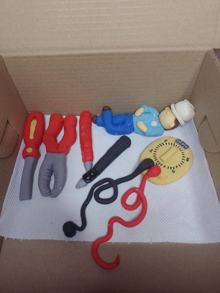 a cardboard box filled with different types of crafting supplies on top of a table