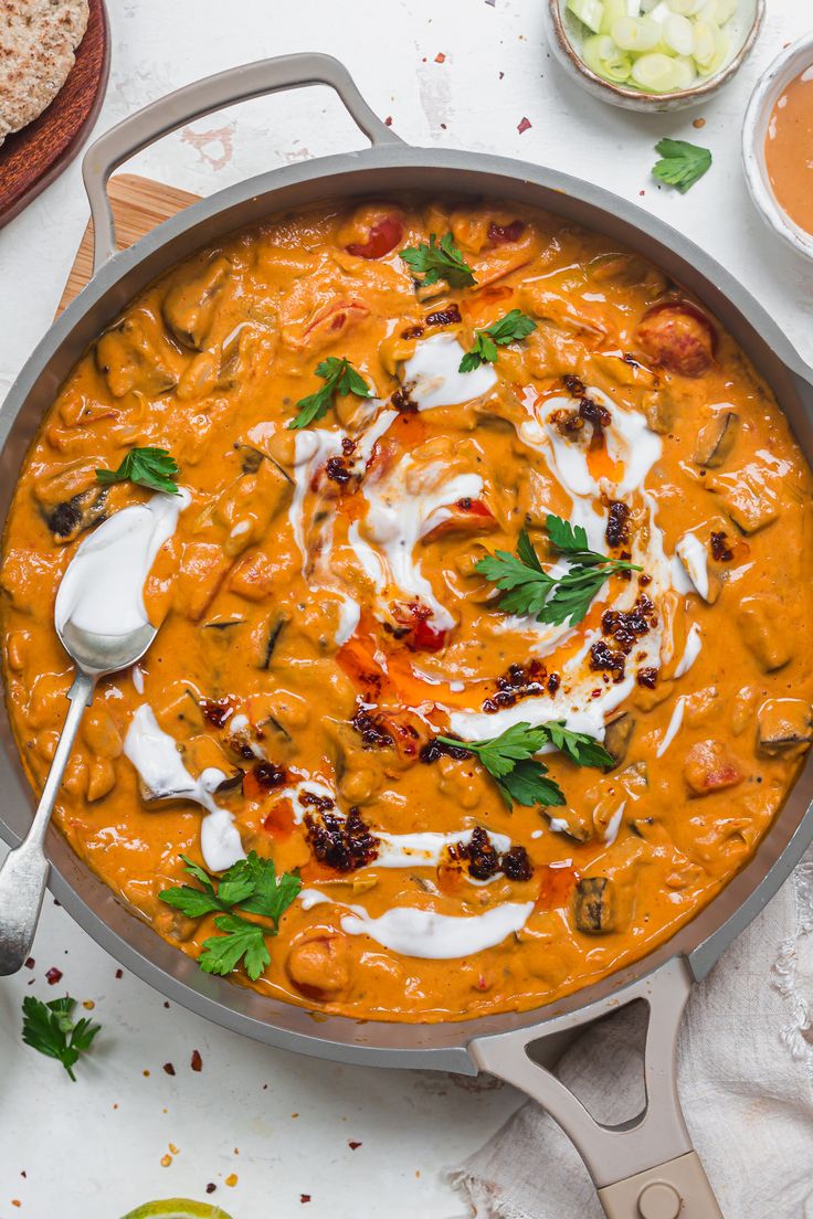 a large pan filled with food on top of a white table next to other dishes