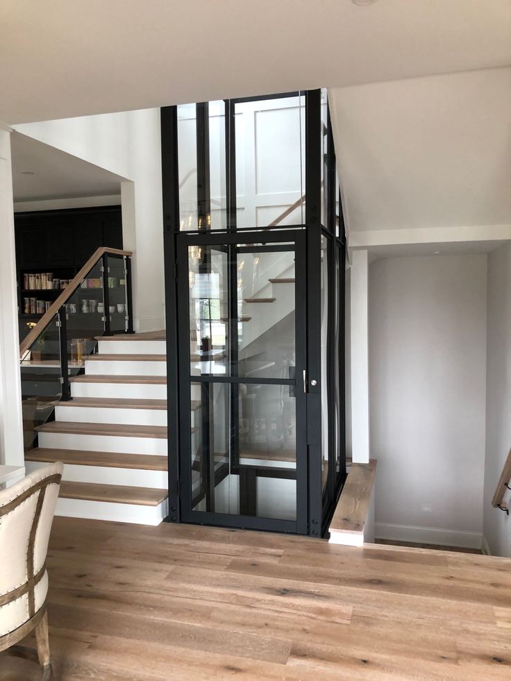 an empty room with stairs and glass doors