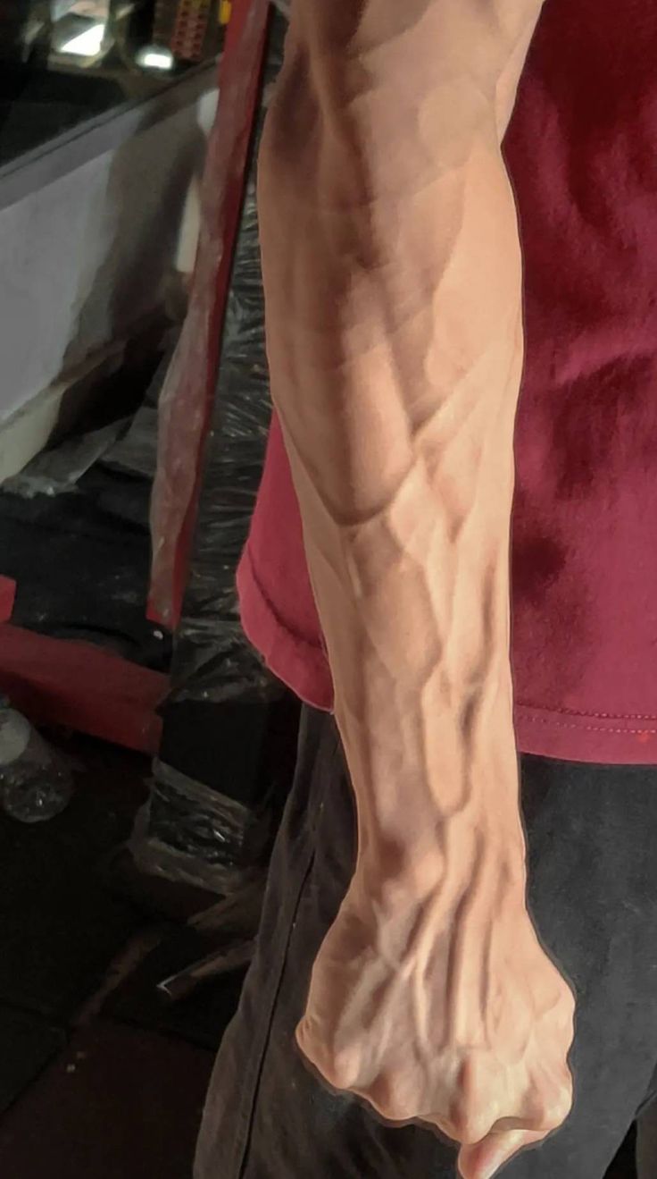 a close up of a person's arm and leg with muscles exposed in the background