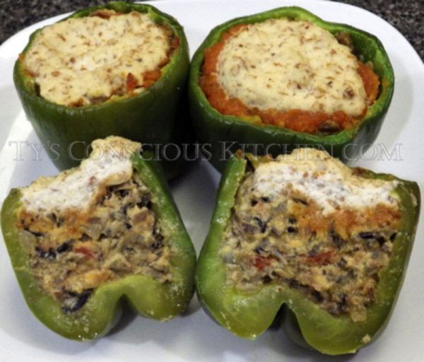 four stuffed green peppers on a white plate