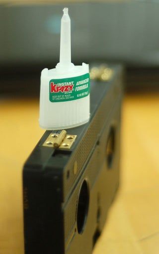 a black box with a white bottle on top of it sitting on a wooden table