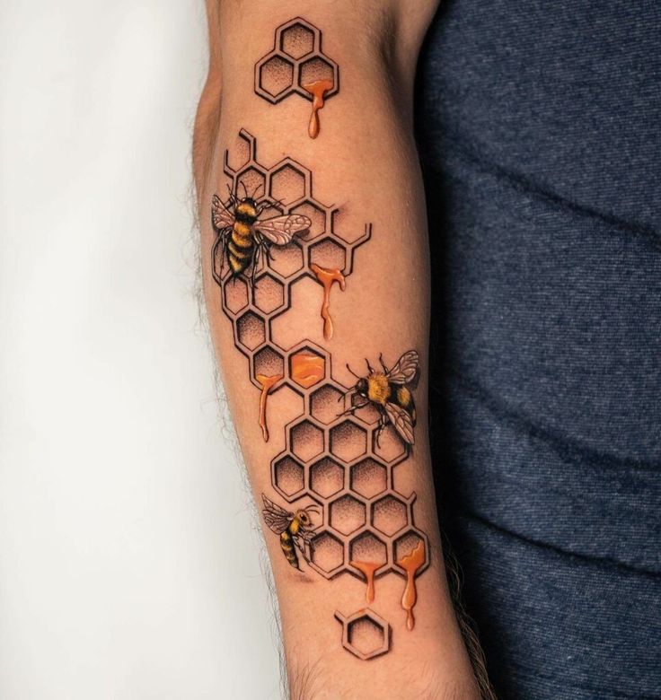 a man's arm with honeycombs and bees on it