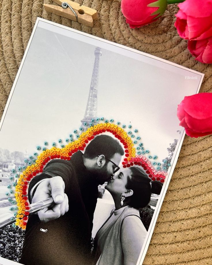 a couple kissing in front of the eiffel tower, with flowers and scissors