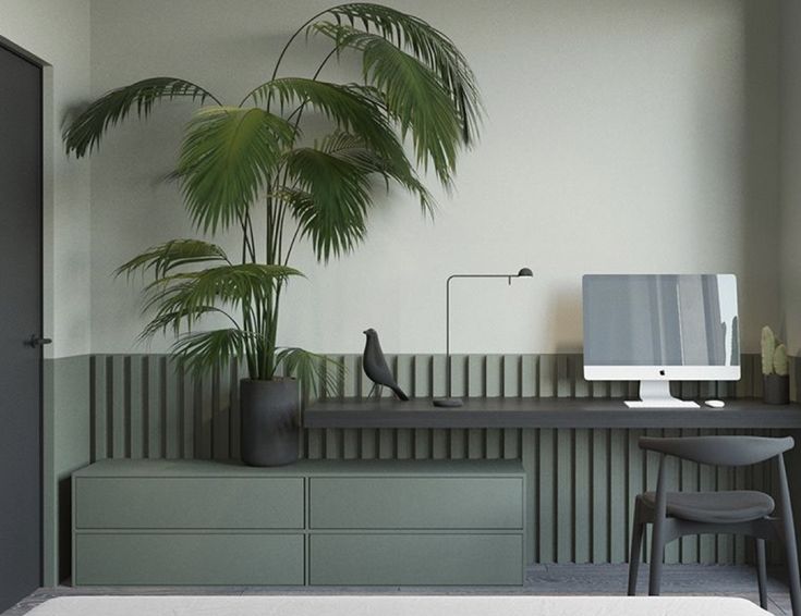 a desk with a monitor, keyboard and chair in front of a palm tree on the wall