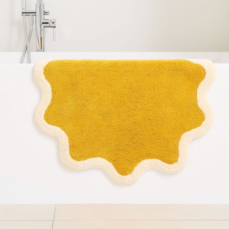 a bath tub with a yellow rug on it