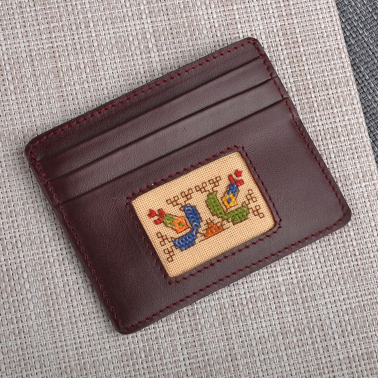 a card case with a cross stitch design on it