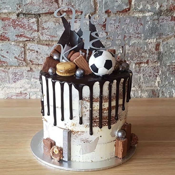 a soccer themed birthday cake with chocolate icing and decorations on top, sitting on a wooden table