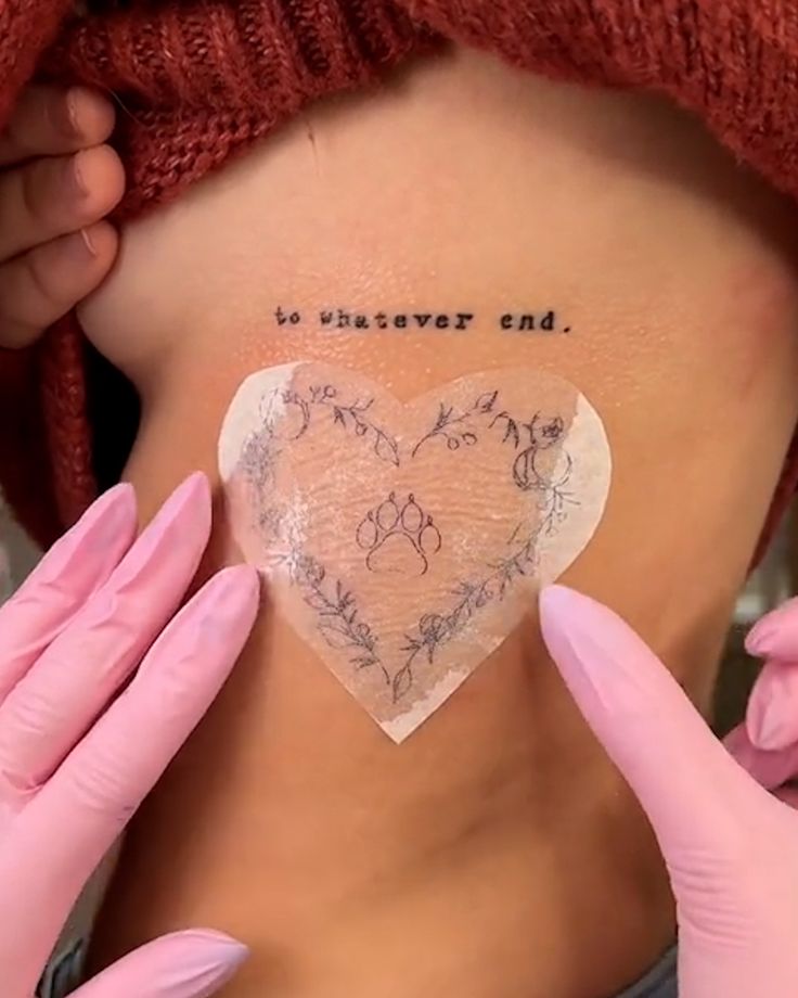 a woman with tattoos on her stomach holding up a piece of paper that says to whatever end