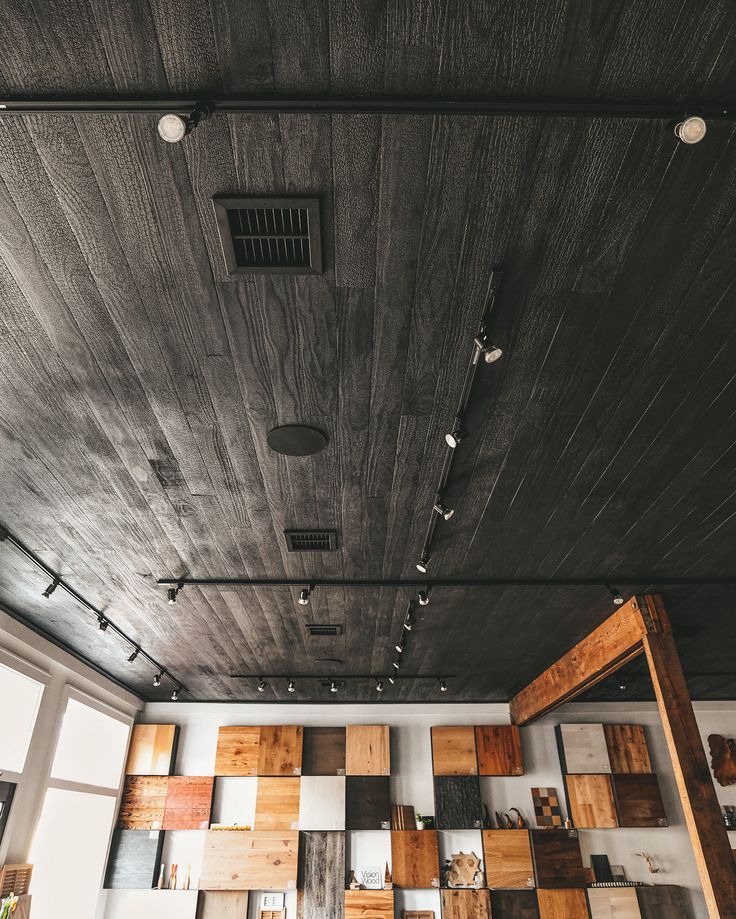 an empty room with wood paneling on the ceiling and wooden shelves in the wall