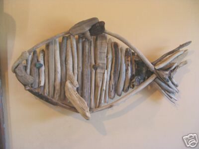 a fish made out of driftwood sitting on top of a wall