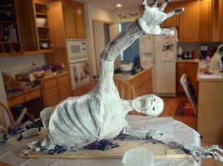 a fake giraffe sitting on top of a table next to a kitchen counter