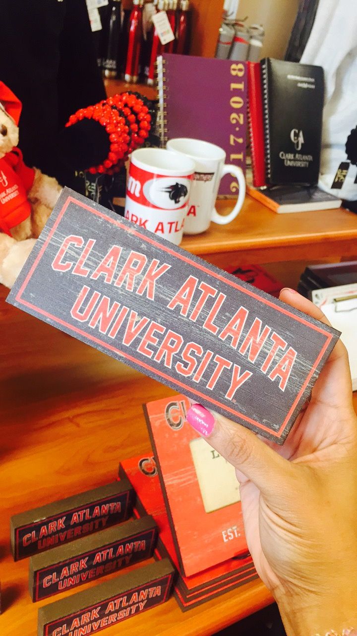 someone holding up a sign that says clark atlanta university in front of some coffee cups