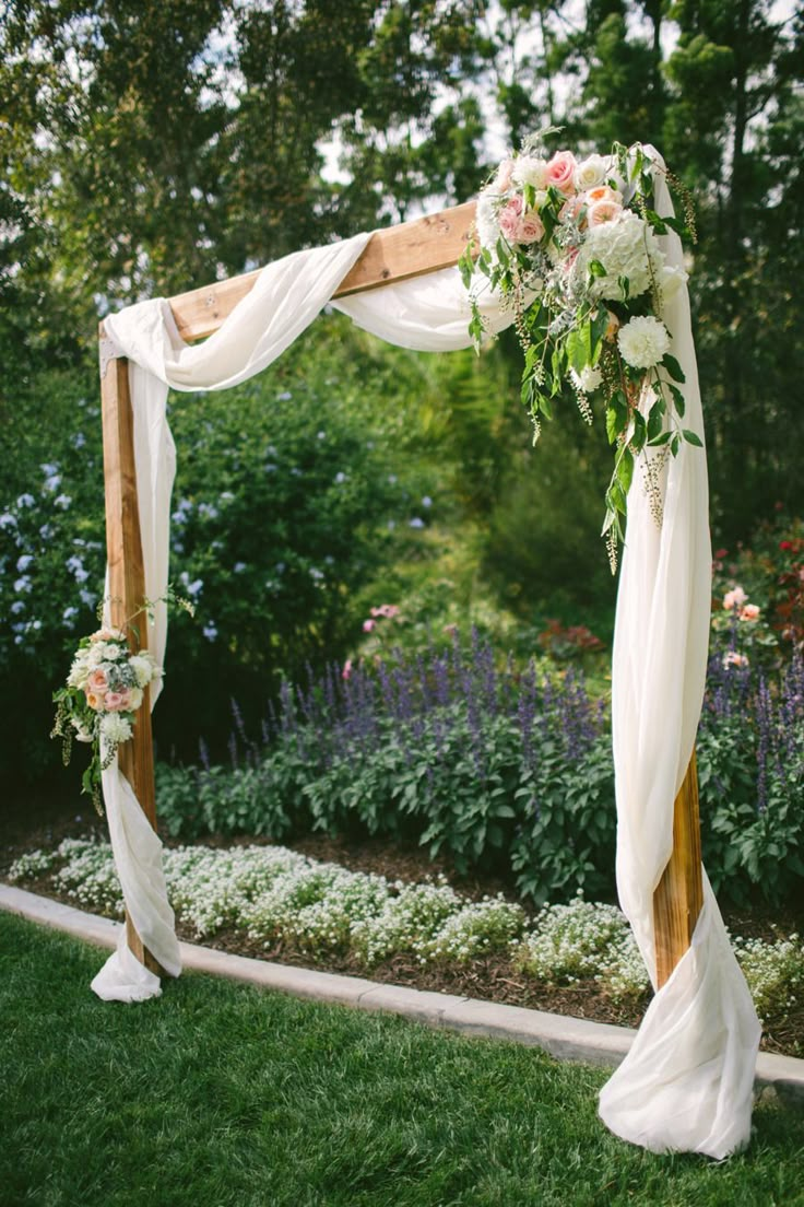 a wedding arch decorated with flowers and greenery