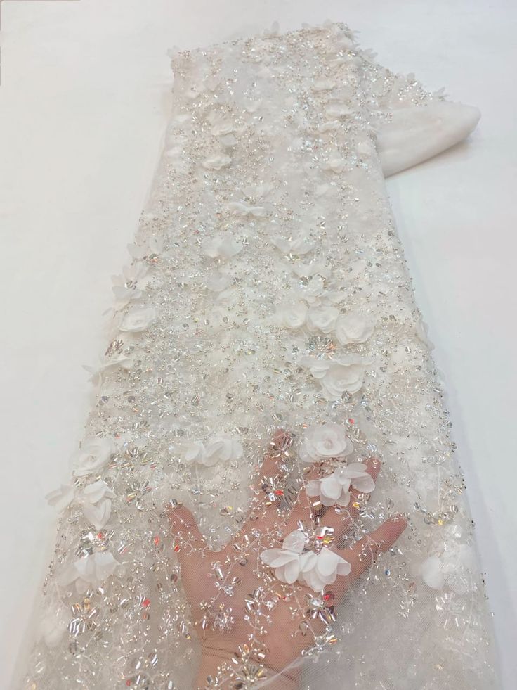 a person's hand laying on the ground covered in crystals