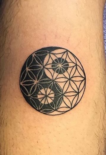 a man with a tattoo on his thigh that has a flower of life in the middle