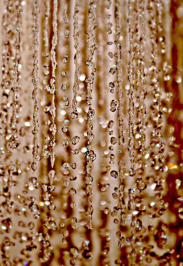 rain drops falling down from the ceiling in front of a window with brown and white background