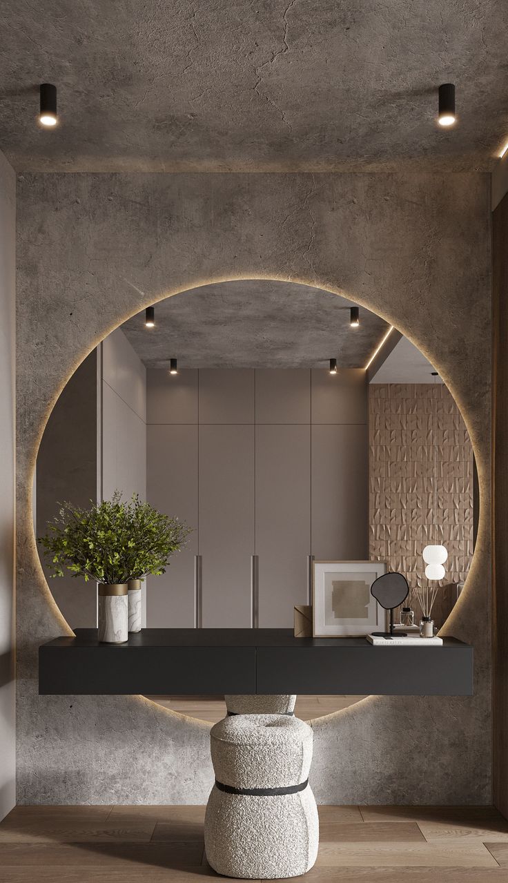 a round mirror on the wall above a table with a potted plant in it