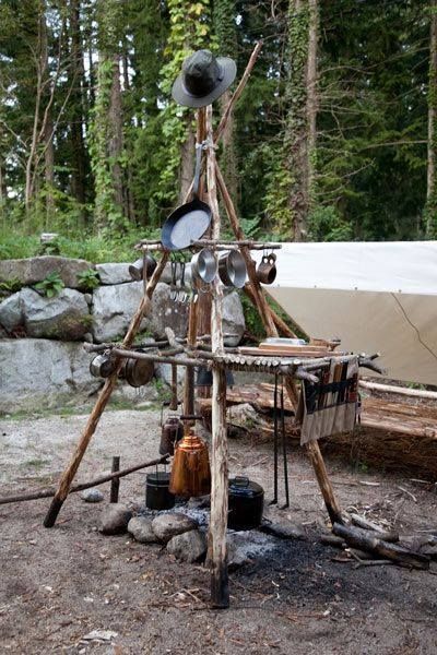 there is a wooden structure made out of various items in the woods with trees and rocks behind it