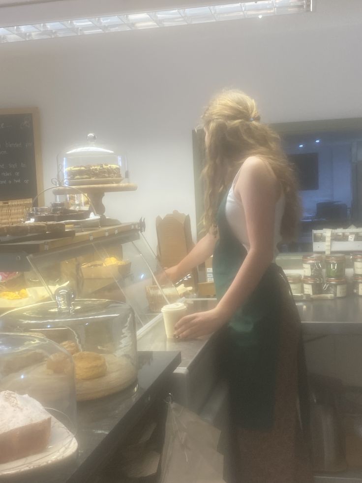 a woman standing in front of a counter preparing food