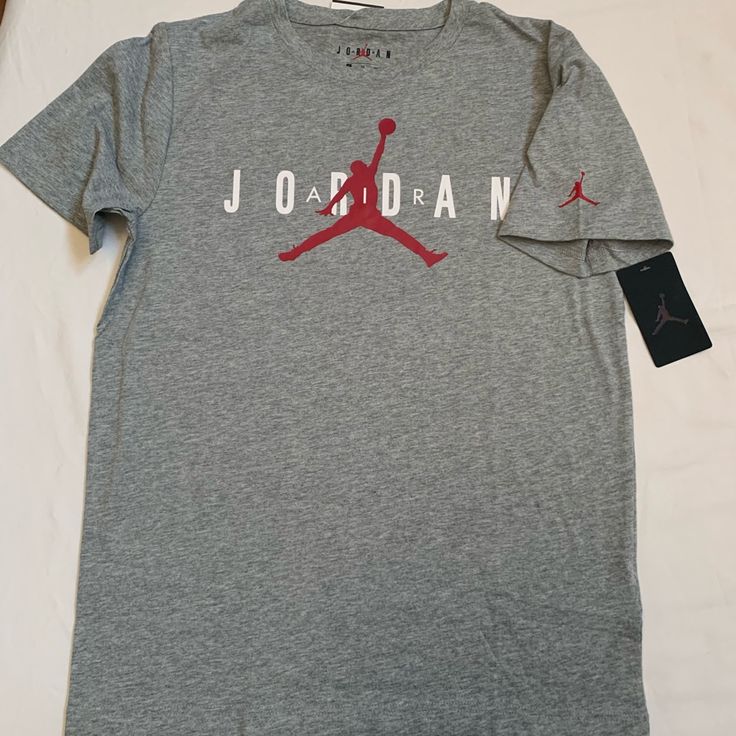 Nike Air Jordan Boy's T-Shirt . Brand New With Tag . Boy's Size : Xl (13-15 Yrs) Color : Dark Grey Heather . Short Sleeve Tee With Graphic . 60%Cotton 40% Polyester Athletic Heather Graphic Tee With Logo Print, Dark Heather Cotton Crew Neck Top, Casual Heather Tops With Letter Print, Heather Casual Tops With Letter Print, Casual Athletic Heather T-shirt With Logo, Casual Heather Sports Tops, Casual Dark Heather Short Sleeve T-shirt, Dark Heather Short Sleeve Casual T-shirt, Gray Cotton Sports Shirt