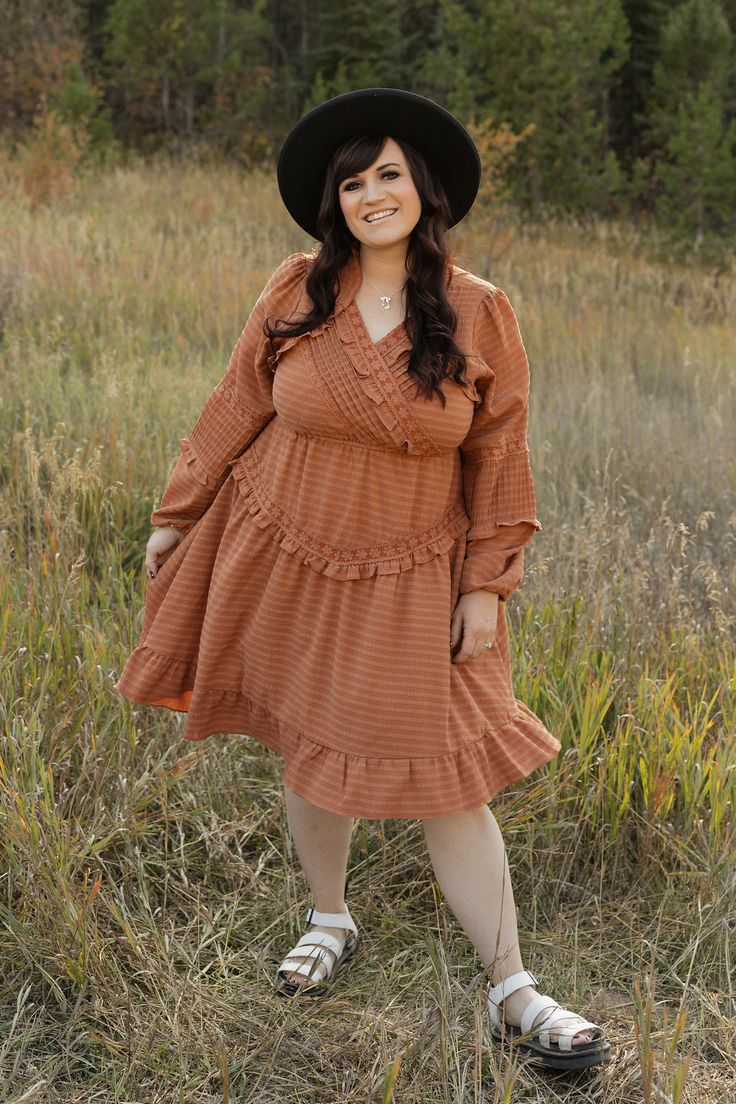 Add a touch of whimsy to your wardrobe with the Libbie Dress-Rust. This knee length dress features pleated detail on the chest and sleeves, along with a v-neckline adorned with embroidered lace. The long sleeves provide coverage while still showcasing the stunning design. Perfect for any occasion, this dress is full of beautiful detail. *Knee length* Material Content: 60% Polyester// 26% Tencel // 14% Spandex // Lining: 100% Rayon Material Pattern: Textured Kirsten is 5'4" wearing a small Model Brown V-neck Dress With Ruffle Hem, Flowy Midi Dress With Surplice Neckline For Fall, Brown V-neck Midi Dress With Ruffles, Brown V-neck Ruffled Midi Dress, Brown Pleated V-neck Dress, Fall Dresses With Ruffles And Surplice Neckline, V-neck Midi Dress With Ruffles For Fall, Fall V-neck Dress With Ruffle Hem, Modest V-neck Dress With Ruffle Hem