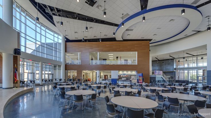 an empty cafeteria with tables and chairs in it