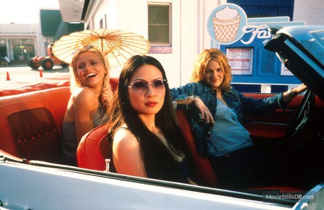 three women sitting in the back of a convertible car