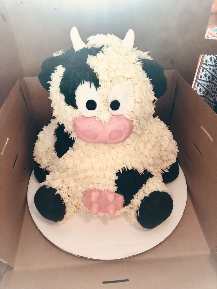 a cake shaped like a cow sitting in a box