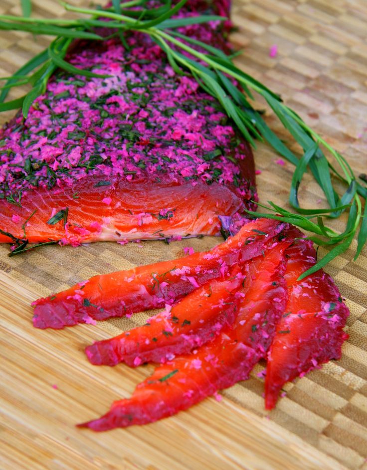 some kind of food that is sitting on a bamboo table with purple stuff around it