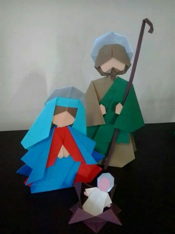 paper cut out of the nativity scene, including two men and a baby jesus