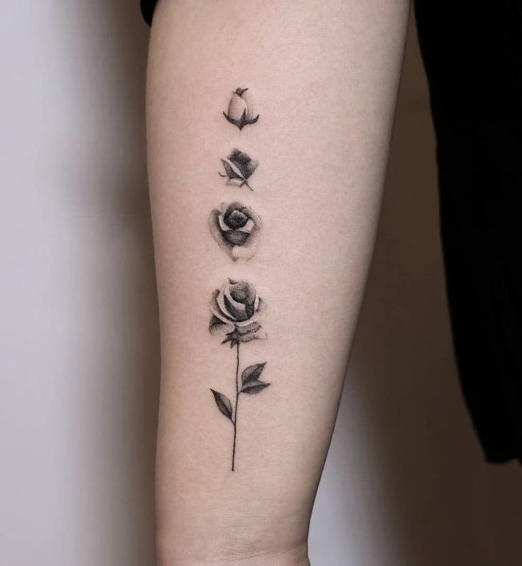 a woman's arm with three roses on it