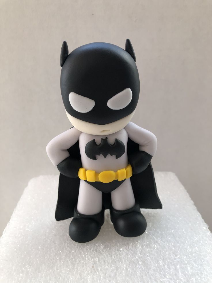 a batman figurine sitting on top of a white surface