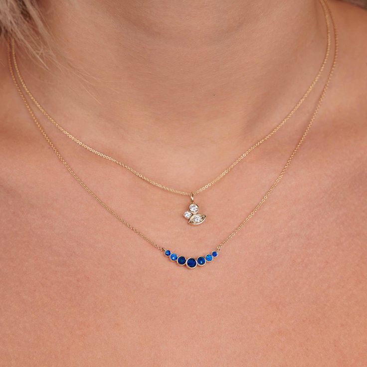 This stunning necklace features a delicate 14k gold chain with a graduated bezel design, adorned with beautiful blue sapphire gemstones. The pendant measures approximately 3/4 of an inch, making it the perfect size for everyday wear or special occasions. The combination of gold and sapphire creates a timeless and elegant look that will elevate any outfit. Diamond And Sapphire Necklace, Sapphire Diamond Necklace, Sapphire Pendant Necklace, Sapphire Diamond Pendant, Sapphire Necklace Pendants, Blue Sapphire Necklace, Bezel Necklace, Batman Arkham, Sapphire Pendant