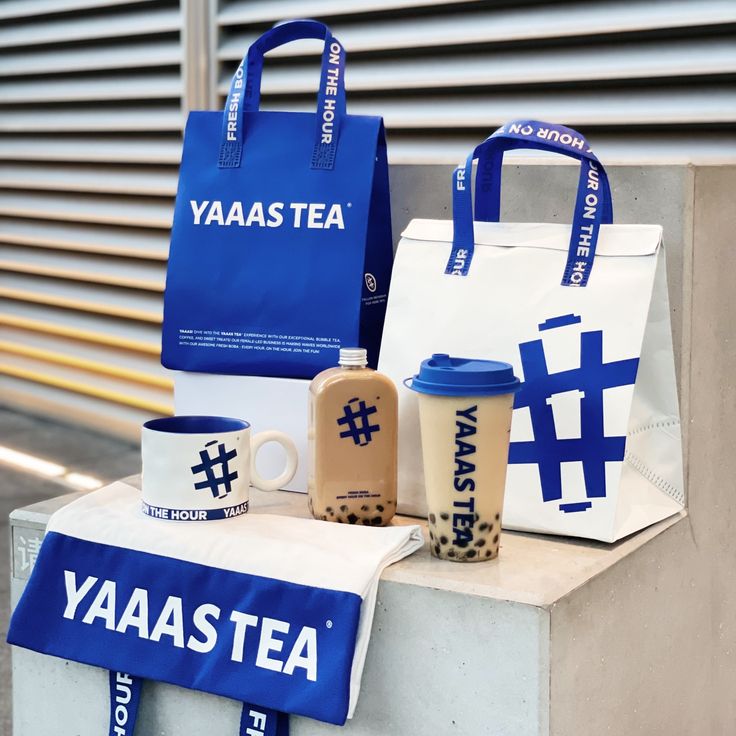 various types of tea bags and cups sitting on top of a cement block with the words yaaastea printed on them