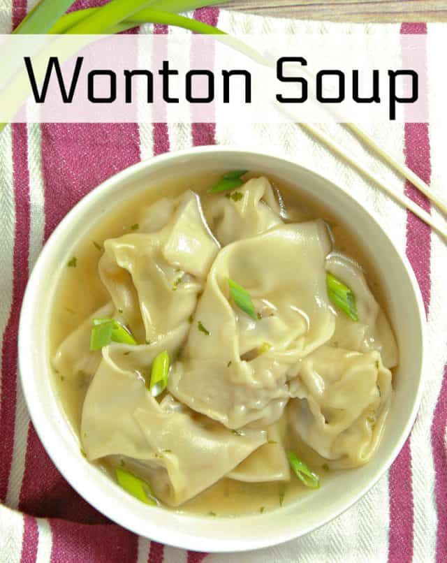 a bowl of wonton soup with chopsticks next to it on a pink and white towel